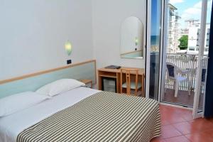 ミラノ・マリッティマにあるHotel Delfinoのベッドルーム1室(ベッド1台付)、バルコニー(デスク付)