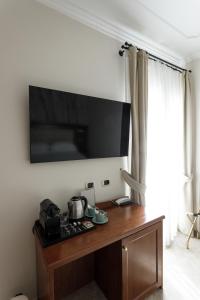 a television on a wall above a stove in a room at Esposizione Luxury Rome in Rome