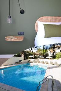a bedroom and a swimming pool with a bed at Hôtel La Garrigue & Bar Piscine in Venasque