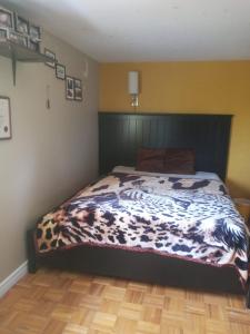 a bedroom with a bed with a cow blanket at ROOM for Rent in Mississauga