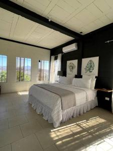 Breathtaking Mountain Views in La Union, El Salvador في لا يونون: غرفة نوم بسرير كبير في غرفة بها نوافذ