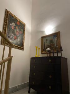 un comò con specchio e una foto su un muro di Casa Vacanze Nonna Maria 