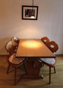 a wooden table with four chairs around it at Fewo 2 - Residenz Schauinsland -Sauna, E-Ladestation, Schauinsland- Todtnauberg, Liftverbund Feldberg in Ennerbach