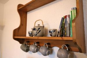 a wooden shelf with cups and books on it at Fewo 2 - Residenz Schauinsland -Sauna, E-Ladestation, Schauinsland- Todtnauberg, Liftverbund Feldberg in Ennerbach