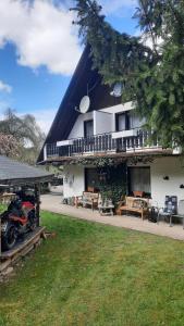 a house with a porch and a motorcycle parked in front of it at Gasthof Walhalja in Schmallenberg