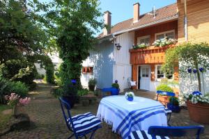 a patio with a table and chairs and a house at Ferienhaus im Gässle, Kirchzarten, Dreisamtal in Kirchzarten