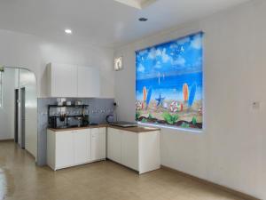 a kitchen with a large painting on the wall at Padang Serai Room Stay Share Bathroom in Padang Serai