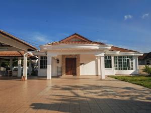 a large white house with a driveway at Padang Serai Room Stay Share Bathroom in Padang Serai