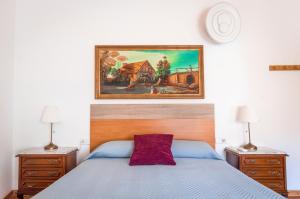 a bedroom with a blue bed and a painting on the wall at Rodenas Valero Alborea in Alborea