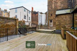 an empty deck with brick buildings and a staircase at Elegant 2 Bed Harbour Front Flat By OC House Short Lets & Serviced Accommodation Gillingham, Ramsgate, Folkestone With Balcony in Kent