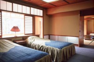 a bedroom with two beds and a window at Yunokaze HAZU in Shinshiro