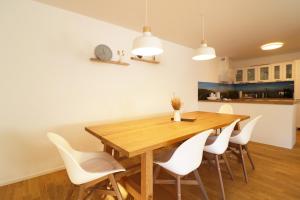 a dining room with a wooden table and white chairs at Haus Wiesenquelle - Fewo 10 "Uff'm Berg", Feldberg in Rinken