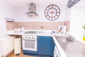 una cocina con fregadero y un reloj en la pared en Seaview Cottage Central Dundee en Dundee