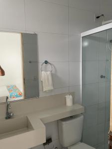 a bathroom with a sink and a toilet and a mirror at Pousada Sol de Amaro in Santo Amaro