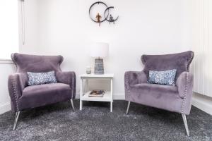 2 chaises violettes et une table dans une pièce dans l'établissement Seaview Cottage Central Dundee, à Dundee