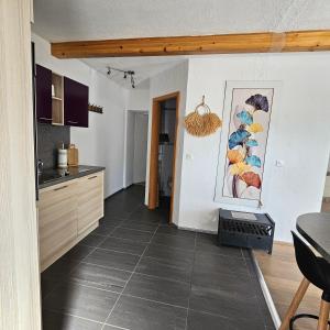 a kitchen with a tile floor in a room at Appartement Les Salines in Roche