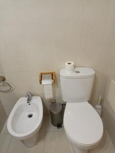 een witte badkamer met een toilet en een wastafel bij esthela home 2 in Funchal