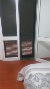 een slaapkamer met 2 deuren en een bed en een houten vloer bij esthela home 2 in Funchal
