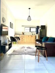 Il comprend un salon avec un canapé et une cuisine. dans l'établissement Apartment close to Menlyn Maine, à Pretoria