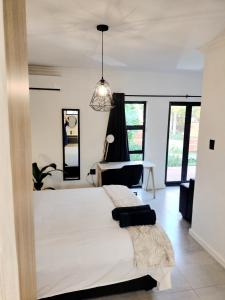- une chambre avec un grand lit dans une pièce dotée de fenêtres dans l'établissement Apartment close to Menlyn Maine, à Pretoria