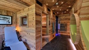 Cabaña con paredes de madera y silla blanca en ARPA DI PIETRA - Luxury B&B SPA BIO en Mori