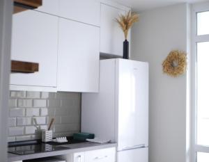 a white kitchen with white cabinets and a window at Prestige Apartments in Rivne