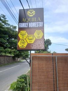 a sign for a family homery on the side of a road at Aquila Family Homestay in Lampung