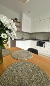 a kitchen with a table with a vase of flowers on it at Prestige Apartments in Rivne