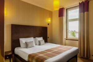 1 dormitorio con 1 cama grande y ventana en Rosslea Hall Hotel en Rhu