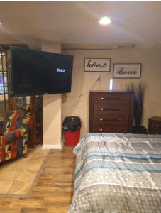 a bedroom with a flat screen tv on the wall at PRIVATE ENTRANCE APT RooM #4 in Dallas