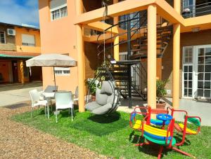 a patio with chairs and a table and a swing at Renacer in Federación