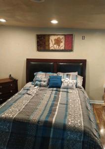 a bedroom with a bed with a blue and white comforter at PRIVATE ENTRANCE APT RooM #4 in Dallas
