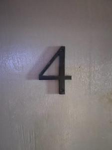 a metal arrow sign on a wall at PRIVATE ENTRANCE APT RooM #4 in Dallas