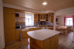 uma cozinha com armários de madeira e uma mesa em Chalupa Bílá stopa - celá chalupa pro jednu partu em Stará Ves