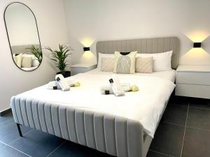 - une chambre avec un grand lit blanc et un miroir dans l'établissement Stilvolles Designappartment mit Terasse & Garten im idylischem Bindlach, à Bindlach