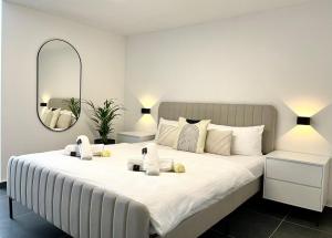Stilvolles Designappartment mit Terasse & Garten im idylischem Bindlach في بيندلاخ: غرفة نوم مع سرير أبيض كبير مع مرآة