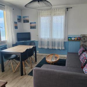 a living room with a table and a couch at Beach Front Apartment Eljocri in Capbreton