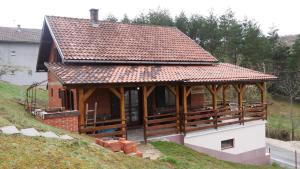 uma casa com um grande telhado numa colina em Kuća za Odmor Naša Priča em Šipovo