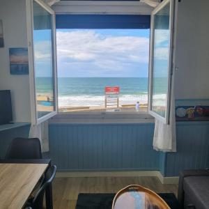 a room with a window with a view of the beach at Beach Front Apartment Eljocri in Capbreton