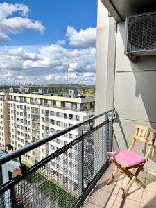 een balkon met een stoel en uitzicht op een gebouw bij cohost I HighRise 65m2 Apt w- Balcony and garage parking, Self check-in in Vilnius