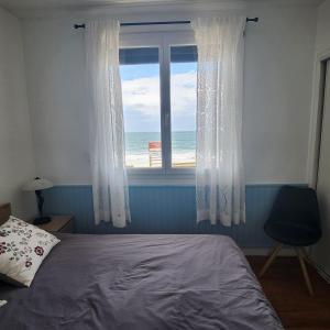 a bedroom with a window with a view of the ocean at Beach Front Apartment Eljocri in Capbreton