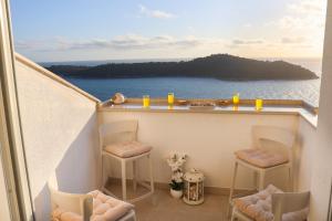 a balcony with chairs and a view of the ocean at Apartment PiccoBello in Dubrovnik
