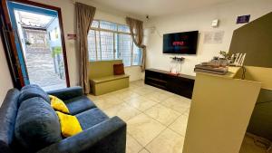 a living room with a blue couch and a tv at Hostel Welcome SP - Congonhas in Sao Paulo