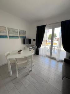 a white table and chairs in a living room with a view at CASA PATTY in Castelsardo +12 photos