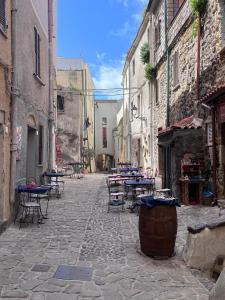 an alley with tables and chairs in an alley at CASA PATTY in Castelsardo