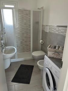 a bathroom with a toilet sink and a washing machine at CASA PATTY in Castelsardo