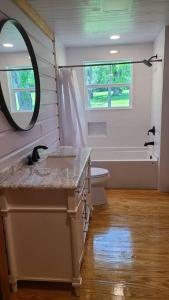 a bathroom with a sink and a toilet and a mirror at Back in time 1940s Lakeview House in South Toledo Bend