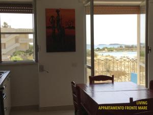 uma cozinha com uma mesa e vista para o oceano em Bilocali Approdo "Fronte Mare" e "Lato Strada" em Porto Cesareo