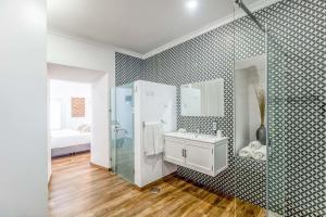 a bathroom with a shower and a sink and a mirror at C`Alma D`Alentejo in Alandroal