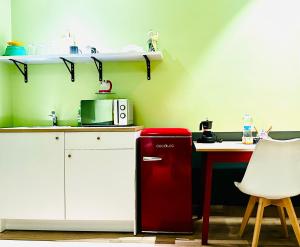 a kitchen with a red refrigerator next to a table at Mini Alloggi Alle Terme in Abano Terme